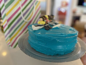 Blue cake with small modeling chocolate people on it