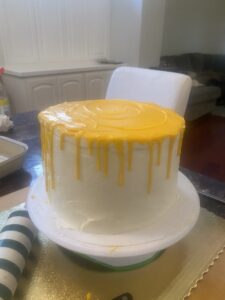 white round cake with yellow melting drips on top